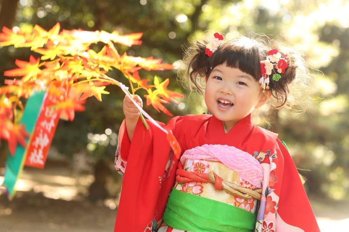 紅葉を持った3歳女の子